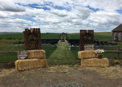 Outdoor wedding ceremony site with chairs, arbor, and rustic decorations